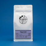White Wonderbean Vijaya Estate washed and sundried coffee pouch against a blue background